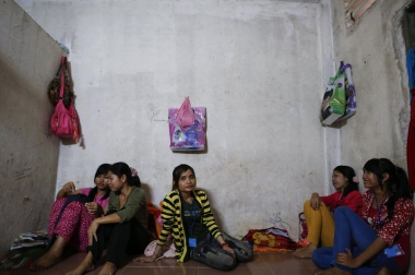 616947-garment-workers-sit-on-the-floor-of-their-apartment-during-a-lunch-break-in-a-suburb-of-phnom-penh.jpg